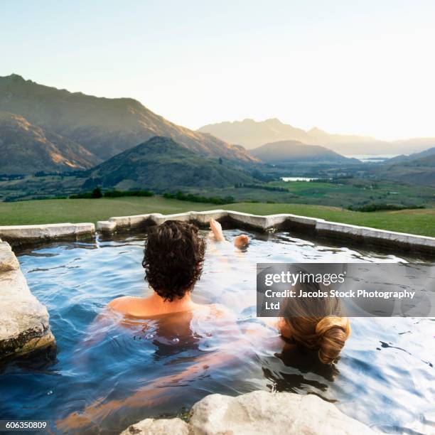 hispanic couple admiring scenic view in pool - porträt frau blick in ferne stock-fotos und bilder