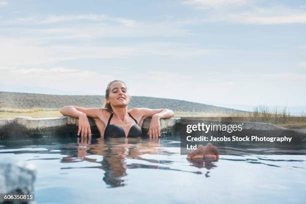 hispanic woman laying in pool - hot tub stock pictures, royalty-free photos & images