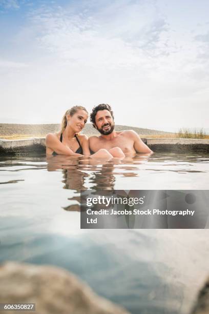 hispanic couple sitting in pool - woman in hot tub stock pictures, royalty-free photos & images