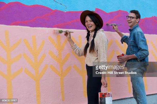 friends painting mural wall outdoors - mural portrait stock pictures, royalty-free photos & images