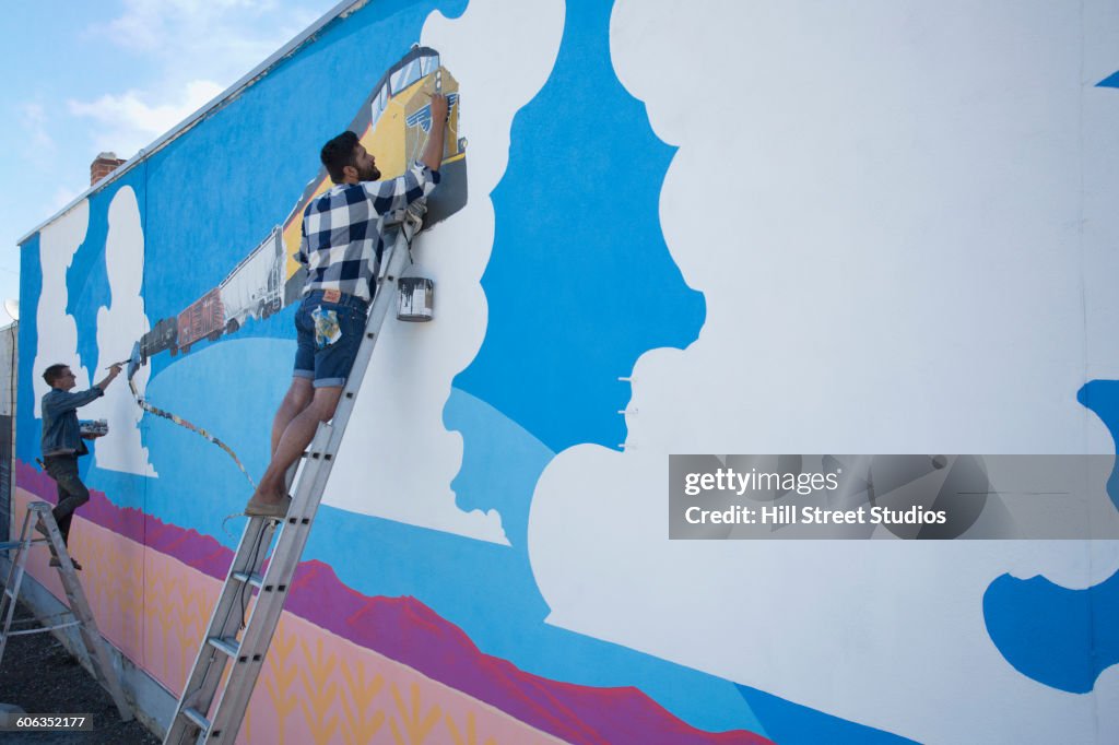 Artists painting mural wall