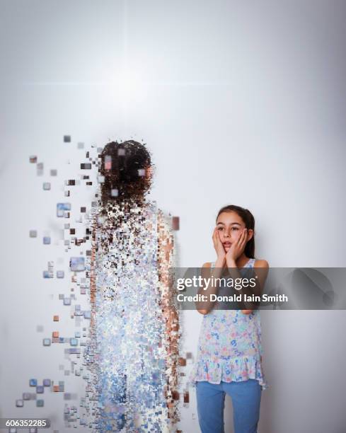 mixed race girl with digital projection of herself - disintegration stock-fotos und bilder