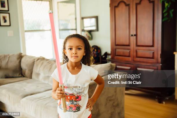 mixed race girl holding light-saber in living room - light sword stock pictures, royalty-free photos & images