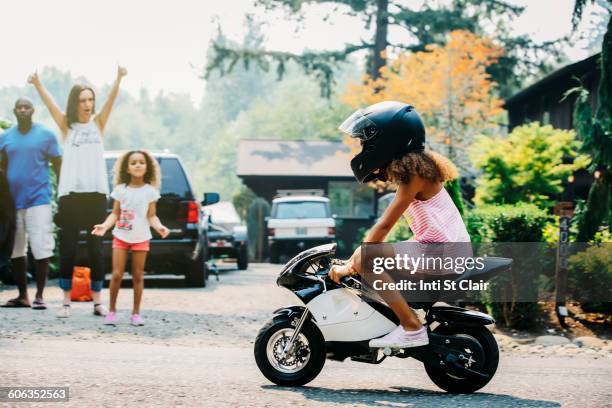 girl riding miniature motorcycle on street - women black and white motorcycle fotografías e imágenes de stock