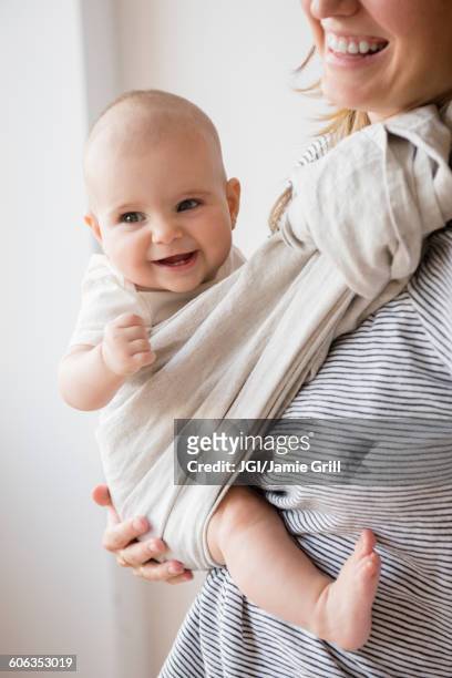 caucasian mother holding baby daughter in sling - bébé rire photos et images de collection
