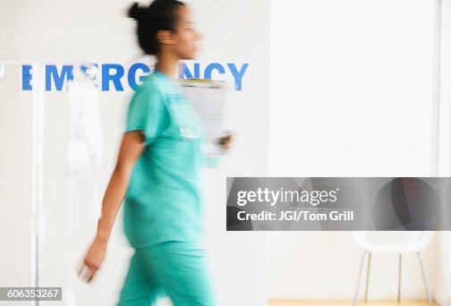 Mixed race nurse walking in hospital Mixed race nurse walking in hospital