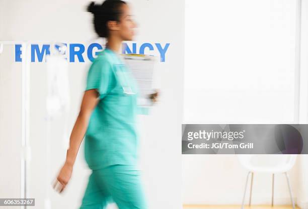 mixed race nurse walking in hospital - hospital blurred motion stock pictures, royalty-free photos & images
