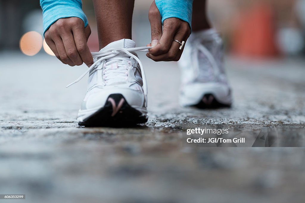 Mixed race runner tying shoelaces