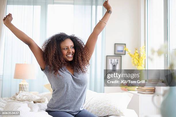 black woman stretching on bed - morning bed stretch fotografías e imágenes de stock