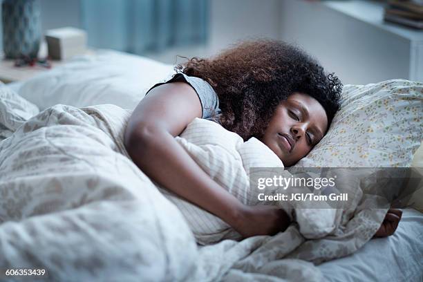 black woman sleeping in bed - dormir imagens e fotografias de stock