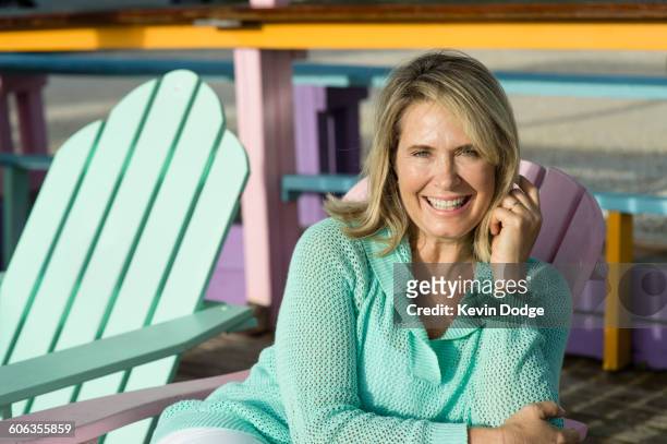 older caucasian woman sitting in lawn chair - adirondack chair closeup stock pictures, royalty-free photos & images
