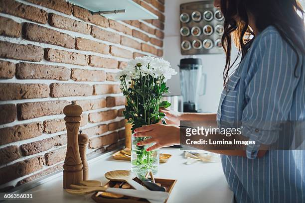 caucasian woman arranging flowers - arrangiare foto e immagini stock