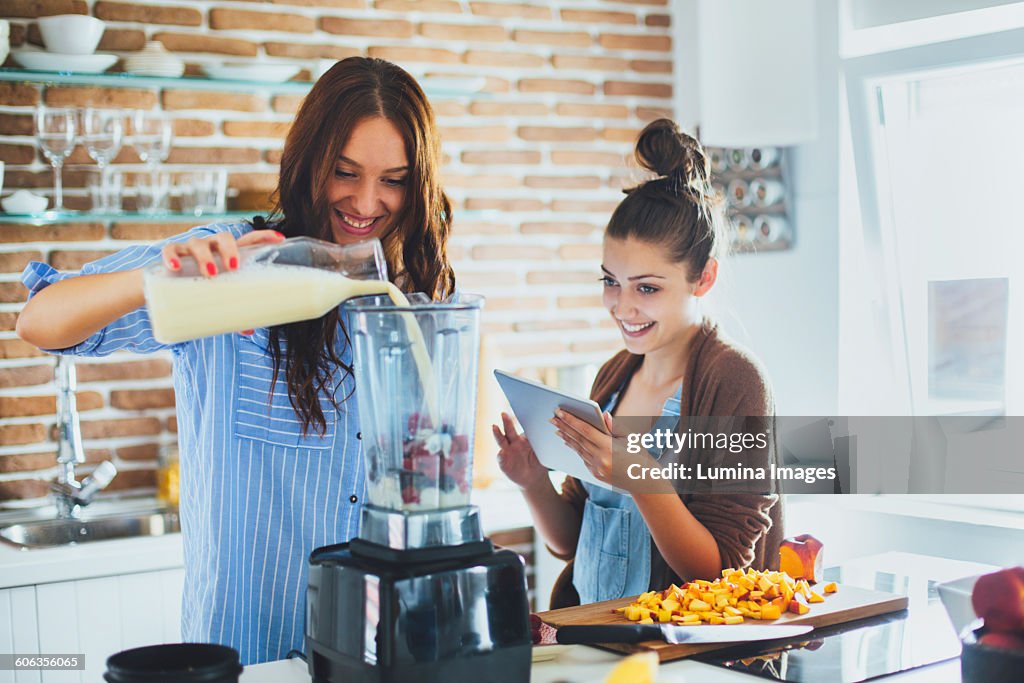 Caucasian women making smoothie in kitchen