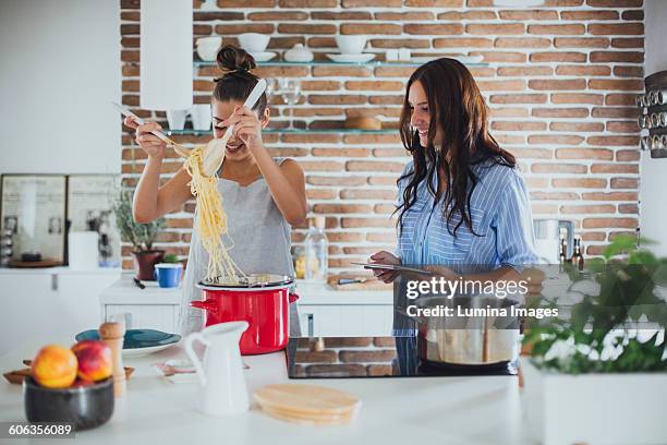 caucasian women cooking pasta in kitchen - cooking pasta stock pictures, royalty-free photos & images