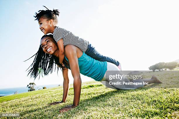 black mother and daughter practicing yoga - mother and child outdoors foto e immagini stock