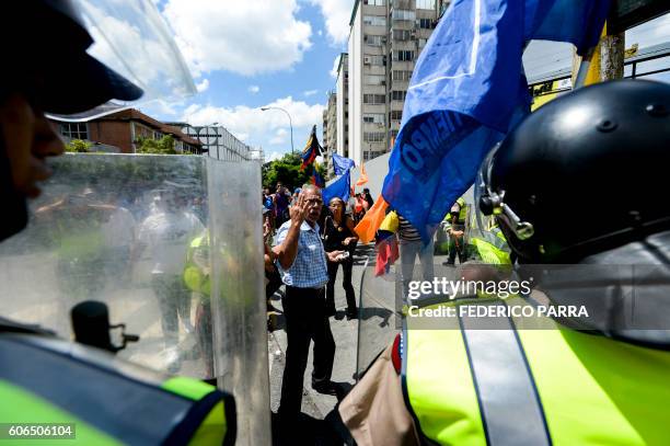 Venezuelan opposition activists are blocked by police during a march in Caracas on September 16, 2016 demanding to the government to set the date for...