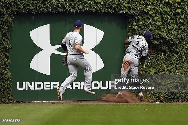 Keon Broxton of the Milwaukee Brewers collides with the left field wall during the third inning of a game against the Chicago Cubs at Wrigley Field...