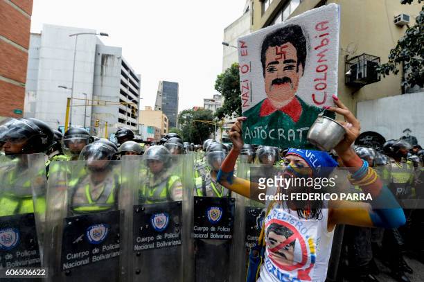 Venezuelan opposition activists are blocked by police during a march in Caracas on September 16, 2016 demanding to the government to set the date for...
