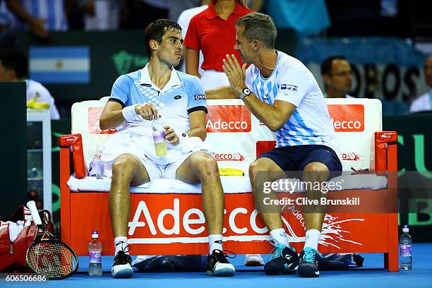 Guido Pella of Argentina speaks with Argentina team captain, Daniel Orsanic during a break in his singles match against Kyle Edmund of Great Britain...