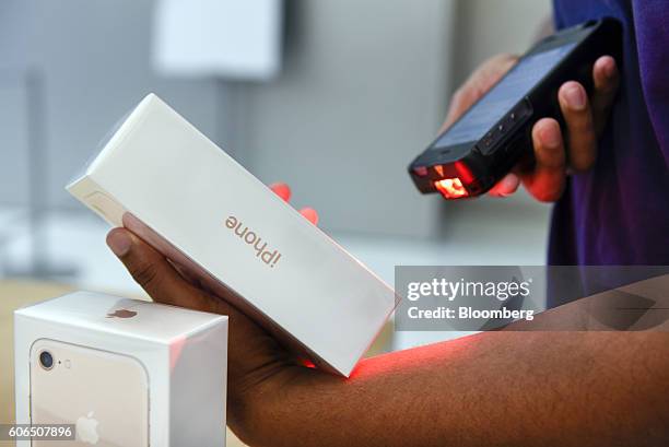 An employee scans an iPhone 7 smartphone for a customer at an Apple Inc. In San Francisco, California, U.S., on Friday, Sept. 16, 2016. Shoppers...