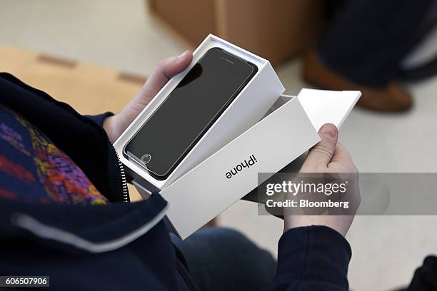 Customer holds a newly purchased iPhone 7 Plus smartphone at an Apple Inc. In San Francisco, California, U.S., on Friday, Sept. 16, 2016. Shoppers...