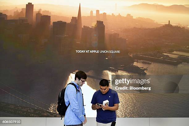 An employee, right, assists a customer with an iPhone 7 Plus smartphone at an Apple Inc. In San Francisco, California, U.S., on Friday, Sept. 16,...