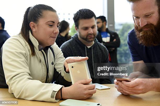 An employee, right, assists a customer with the iPhone 7 Plus smartphone at an Apple Inc. In San Francisco, California, U.S., on Friday, Sept. 16,...