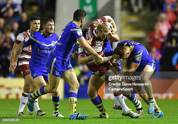 Wigan Warriors' Dom Crosby is tackled by Warrington Wolves' Jack Hughes and Chris Hill during the First Utility Super League Super 8s Round 6 match...