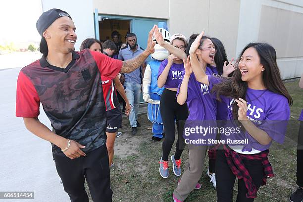 Andre De Grasse dishes out some high fives to some excited students. Olympic triple sprint medalist, Andre De Grasse returns his alma mater, Milliken...