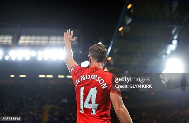 Liverpool's English midfielder Jordan Henderson waves to the fans following the English Premier League football match between Chelsea and Liverpool...