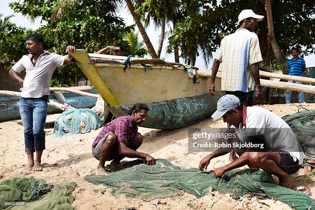 Fishermen gathering fish from net on beach