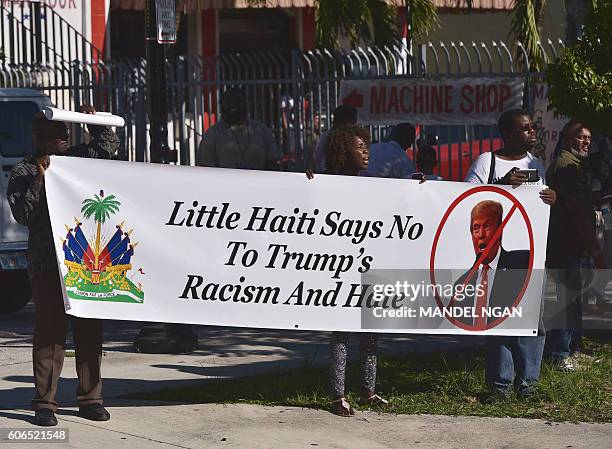Protestors hold a banner as Republican presidential nominee Donald Trump arrives in Little Hati for a town hall meeting in Miami, Florida on...