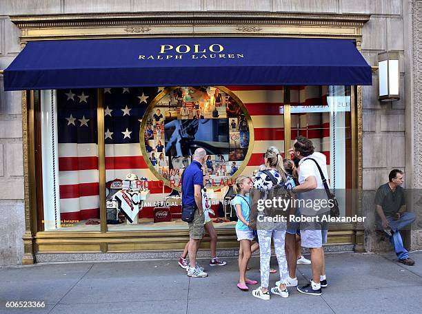 August 27, 2016: New York City shoppers and visitors pause on their walk along Fifth Avenue to admire the window display at the Polo Ralph Lauren...