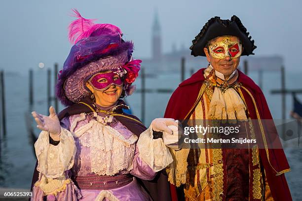 creativity in venice carnival costumes and acts - venetiaans masker vasthouden stockfoto's en -beelden