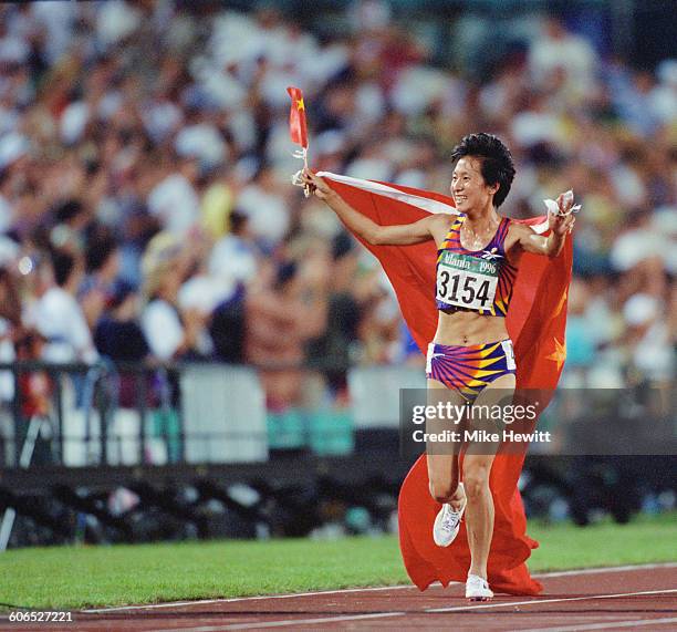 Chinese long-distance runner Wang Junxia celebrates after winning the Women's 5000 metres event on 28th July 1996 during the XXVI Summer Olympic...