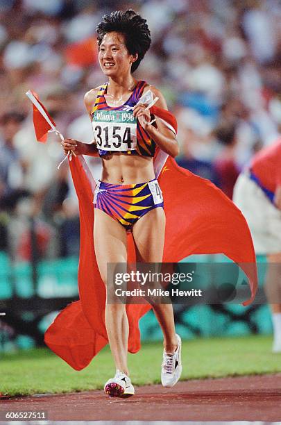 Chinese long-distance runner Wang Junxia celebrates after winning the Women's 5000 metres event on 28th July 1996 during the XXVI Summer Olympic...