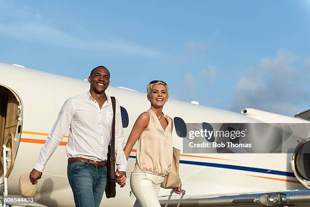 executive jet passengers - couple airplane stockfoto's en -beelden