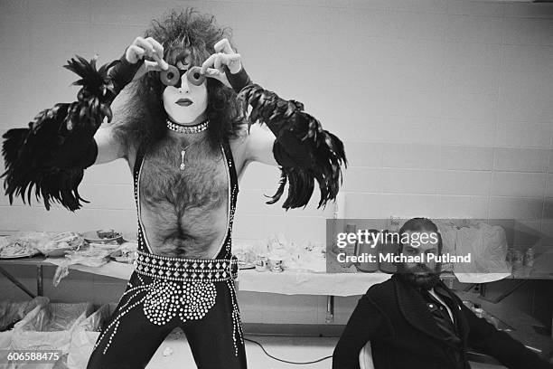 Singer and guitarist Paul Stanley American heavy metal group Kiss peering through a pair of doughnuts, backstage during the band's Rock & Roll Over...