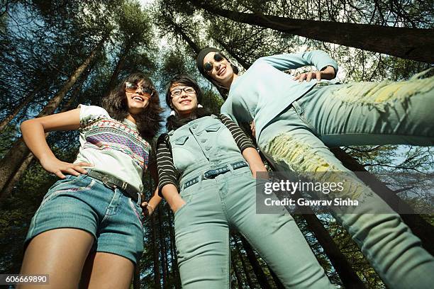 wurmblick von glücklichen freundinnen unterschiedlicher ethnischer herkunft. - hände in den taschen stock-fotos und bilder