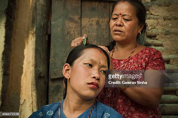 domestic life of asian peasant women, combing her daughter-in-law’s hair. - glimpses of daily life in nepal stock pictures, royalty-free photos & images