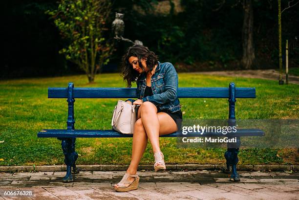 young woman looking inside her purse - purse contents stock pictures, royalty-free photos & images