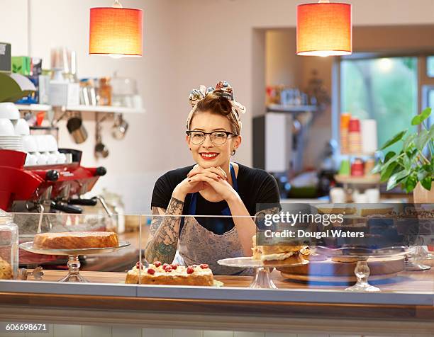 woman behind counter in cake shop. - cosmetics counter stock pictures, royalty-free photos & images