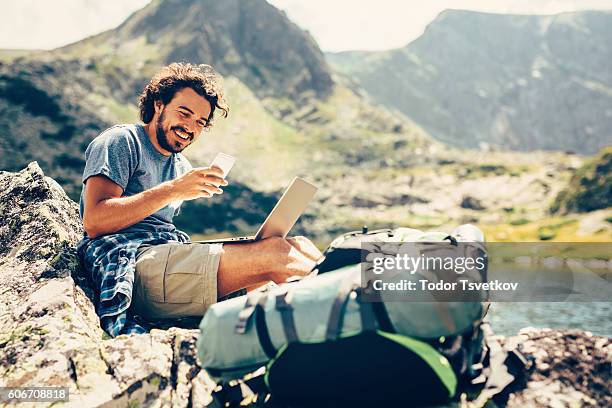 mann sms im berg - rucksacktourist stock-fotos und bilder