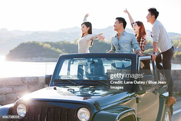 friends having fun in a jeep - mann ganzkörper lachen stehen stock-fotos und bilder