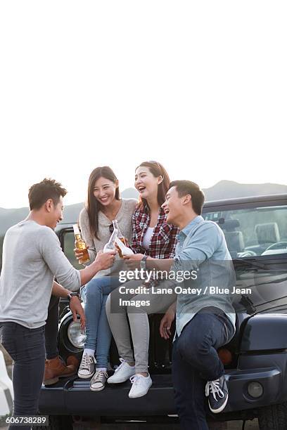 happy friends drinking beer on a jeep - double date stock pictures, royalty-free photos & images