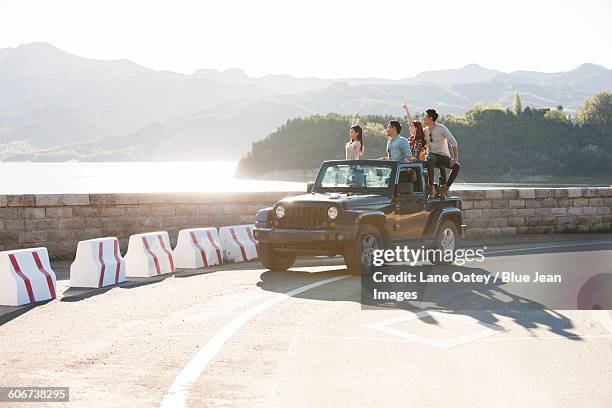 friends having fun in a jeep - asian couple car stockfoto's en -beelden