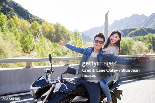 Young couple riding motorcycle together Young couple riding motorcycle together