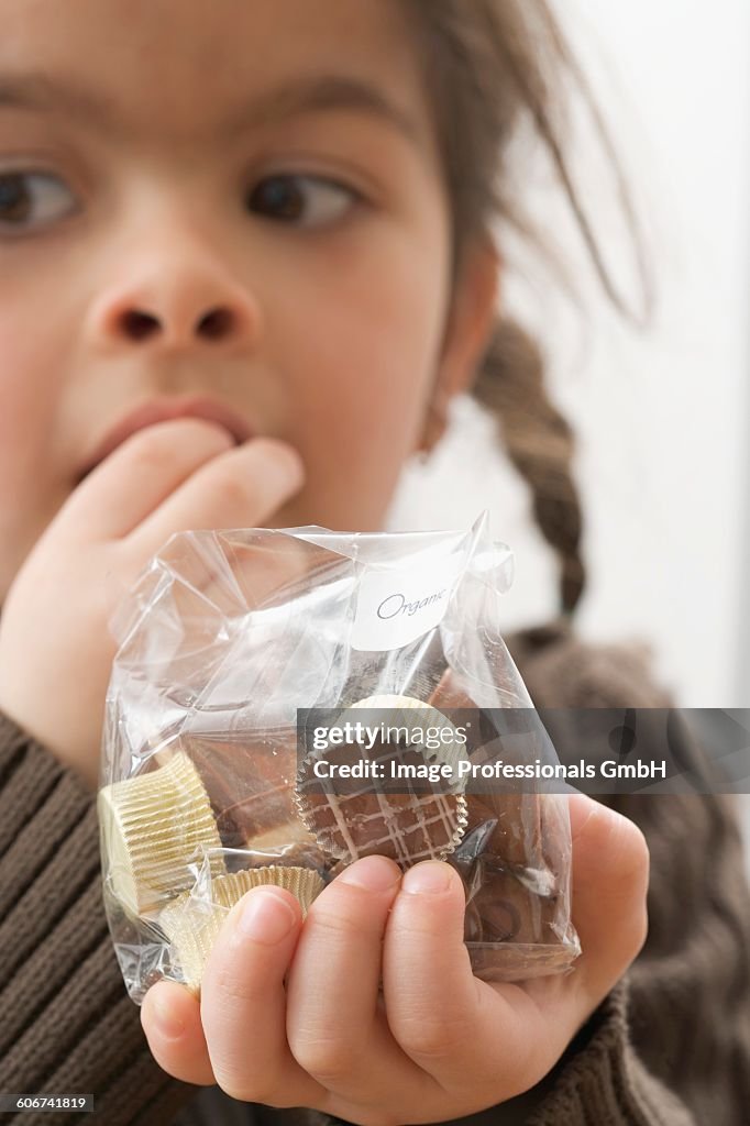 Girl eating chocolates out of a bag