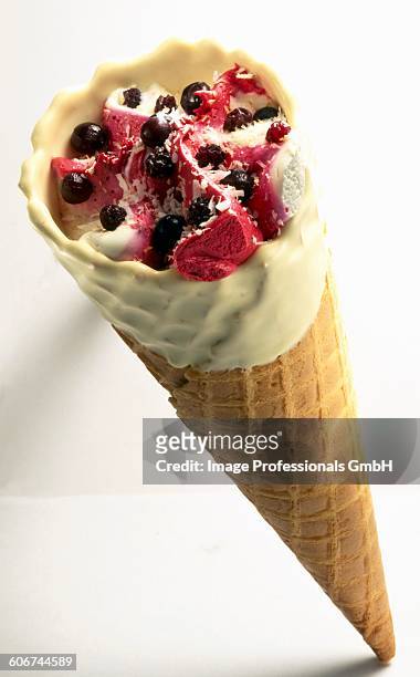 vanilla and summer fruit ice cream cone - cassis fruit stock-fotos und bilder