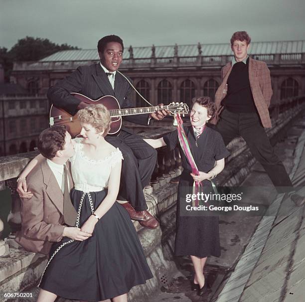 Students on the roof of Trinity College in Cambridge, with the Wren Library in the background during May Week, June 1954. The young man at the back...